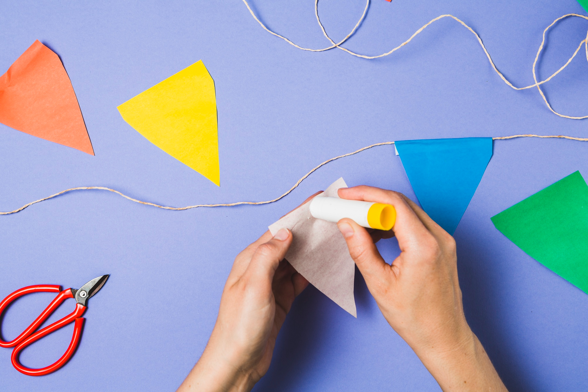 Person Hand Sticking Bunting Paper With Glue Stick
